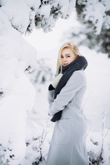 portrait of a young blonde girl in winter forest