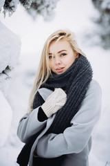 portrait of a young blonde girl in winter forest