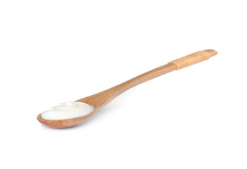 Wooden spoon with sour cream on white background