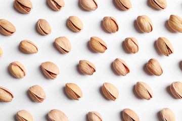 Organic pistachio nuts on white background, flat lay