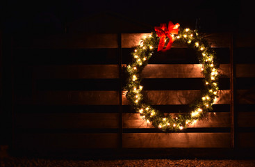 a Christmas wreath on a wooden farm gate