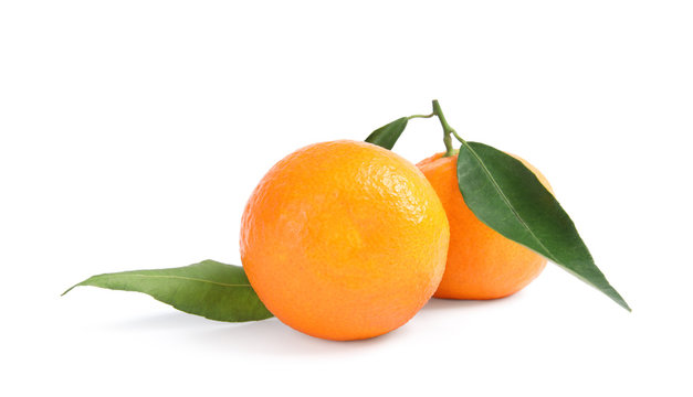 Tasty ripe tangerines with leaves on white background