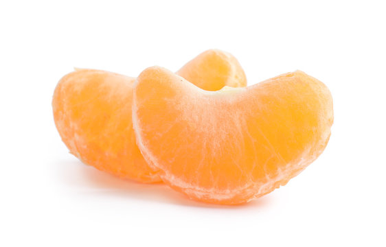Pieces of ripe tangerine on white background