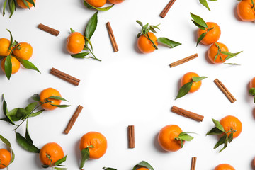 Christmas composition of cinnamon and ripe tangerines with space for text on white background, flat lay