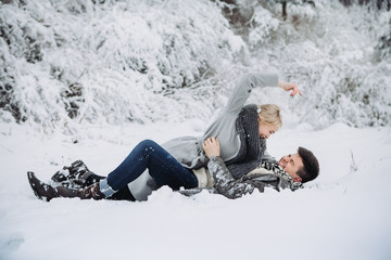 Fototapeta na wymiar Happy young couple have fun outside in snow park