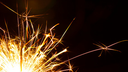 Christmas sparkler isolated on black background. Bengal fire