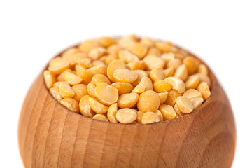 Dry yellow peas on wooden bowl isolated on white background