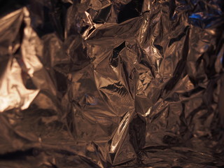 A surface with many faces. Silver metallic luster. Crumpled foil.