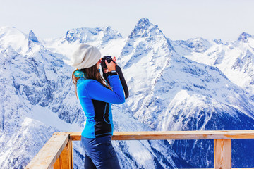 Traveler with camera taking photo of mountains.