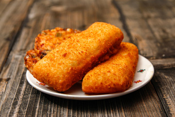 Crispy breaded fried fish fillet and vegetarian burger made from various type of vegetables on old wooden table