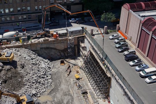 New York City, New York, USA: Workers use a cement mixer with a long arm to construct a retaining wall as construction begins on a high-rise apartment building in Manhattan.