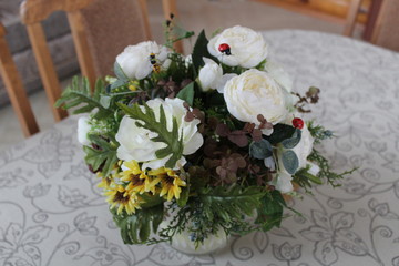 Beautiful bouquet from white roses and camomiles with a green branch in a vase
