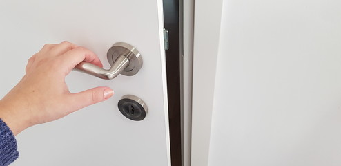 Naklejka premium white door opening girl's hand on metla door handle