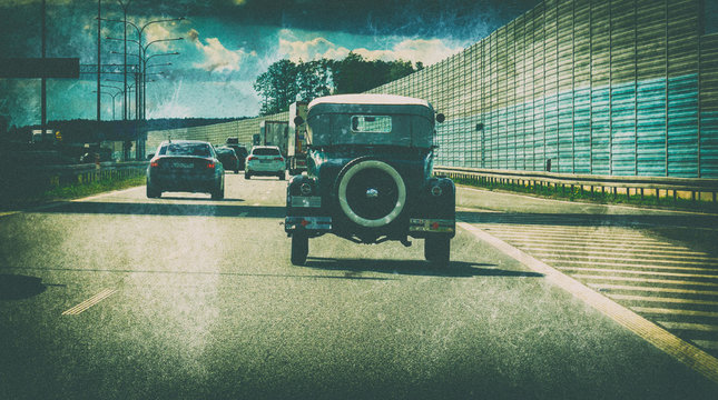 Old Model Vintage Car Driving On The Highway With Modern Cars.