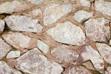 Masonry from granite. Small pieces of stone with cement. Background