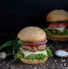 sandwich with two meat cutlets, cheese and vegetables