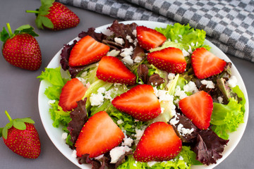 Vegetarian delicious fresh salad with purple and green lettuce leaves, strawberries and goat cheese...
