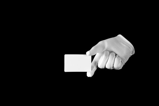 Hand in a white glove on a black background. Credit card. Gesticulation.