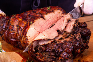 A sharp knife the cook undresses a pork leg