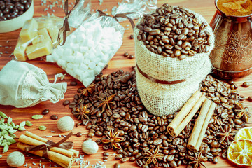 Obraz na płótnie Canvas coffee beans and spices on an old wooden background, anise, cinnamon and nutmeg