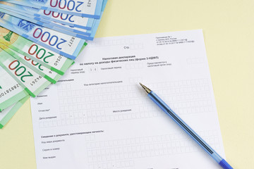 The blank form of the tax document in the Russian language "Declaration on the tax to incomes of physical persons (form 3-NDFL)", pen and new money