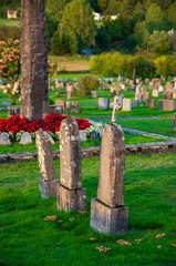 three gravestones of an old viking cemetery with a monolith in background in norway