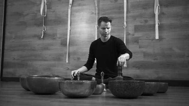 Men plays on Tibetan bowls