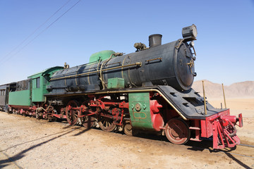 Fototapeta na wymiar Steam train on a tracks in the desert