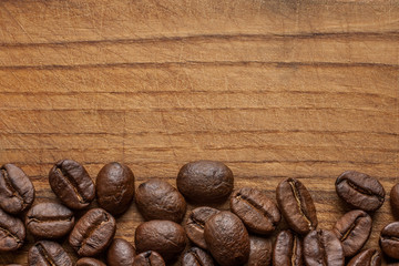 Roasted coffee beans on dark oak wood texture