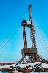 Fototapeta premium Drilling a deep well with a drilling rig at an oil and gas field. The deposit is located in the Far North beyond the Arctic Circle. The shooting was conducted in the winter during the polar day