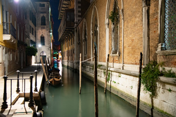Night view of a rivo in Venice, Italy. Night atmosphere with lights and boats on typical Venetian boats.