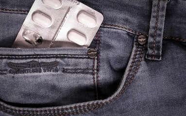 
Blister pack of white pills in jeans pocket