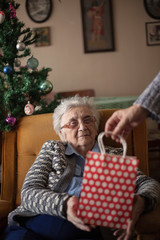Elderly woman receiving a gift from daughter.