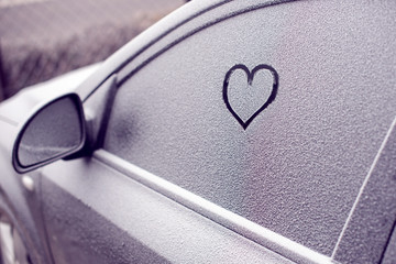 heart symbol on frozen car window in winter