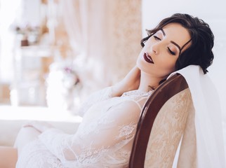 Fototapeta premium Morning of fiancee.Portrait of beautiful young woman in white peignoir
