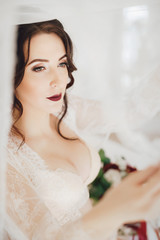 Morning of fiancee.Portrait of beautiful young woman in white peignoir