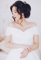 Beautiful brunette bride with stylish make-up in white dress