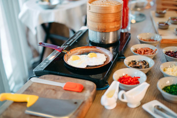 Breakfast. Scrambled eggs are cooked on an induction cooker in the restaurant.