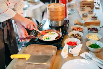  Breakfast. Scrambled eggs are cooked on an induction cooker in the restaurant. © davit85
