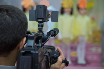 Video Camera recording kindergarder room with blurred background, copy space - Image . Video camera operator working with his equipment - Image