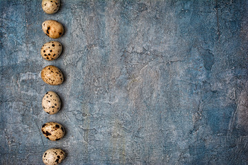 Top view on small quail eggs on blue concrete