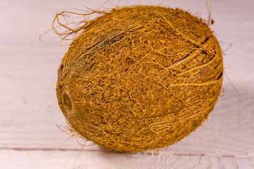 One whole coconut on a wooden table. Top view