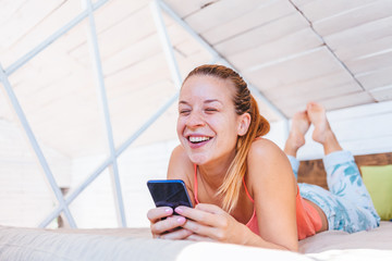 Young woman using cellphone at home, happy connection