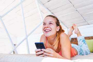 Young woman using cellphone at home, happy connection