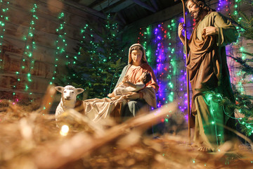 Christmas Manger scene with figures including Jesus, Mary, Joseph, sheep and magi. Soft focus