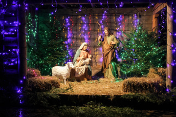 Christmas Manger scene with figures including Jesus, Mary, Joseph, sheep and magi. Soft focus