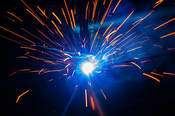 Spark of the electric welding with the sparks of burning hot metal..