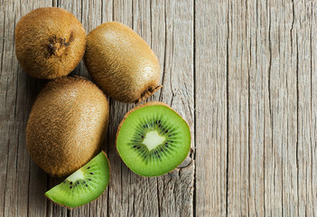 Fresh ripe sliced kiwi fruit, whole half and piece organic juicy kiwi fruits on wooden background
