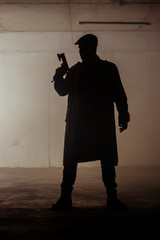 Silhouette assassin man holding pistol