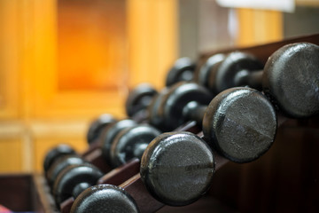 many metal dumbbells on rack
